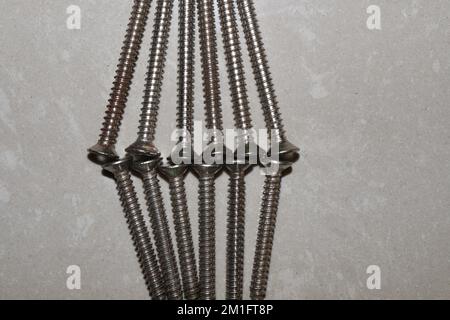 Ancoraggi autoperforanti in plastica per pareti a secco con viti autofilettanti a testa piatta Phillips Foto Stock