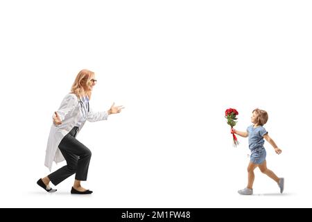 Bambina che tiene rose rosse e che corre verso un medico femminile isolato su sfondo bianco Foto Stock