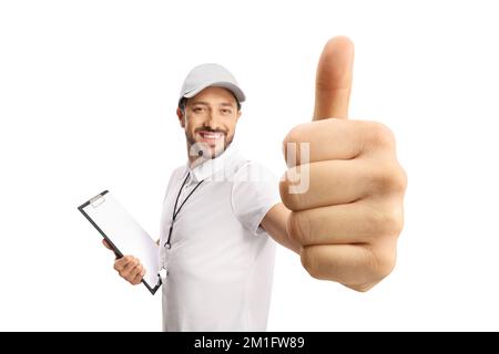 Allenatore sportivo con un fischio che tiene un clipboard e mostra i pollici isolati su sfondo bianco Foto Stock