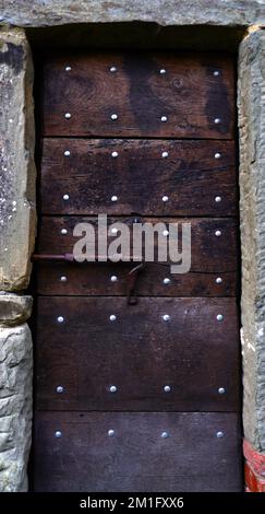 Vecchia porta d'ingresso in legno in vecchia casa rurale italiana in pietra Foto Stock