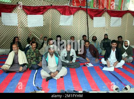 I membri dell'Associazione dei lavoratori municipali del Balochistan stanno organizzando una manifestazione di protesta contro il mancato pagamento dei loro stipendi in un campo di protesta a Quetta lunedì 12 dicembre 2022. Foto Stock