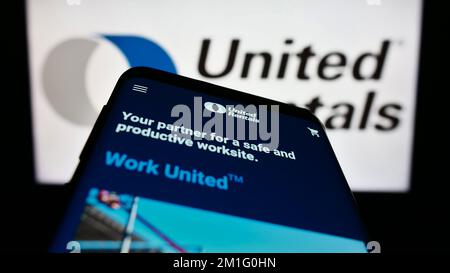 Smartphone con sito Web della società di noleggio attrezzature USA United Rentals Inc. Sullo schermo di fronte al logo. Messa a fuoco in alto a sinistra del display del telefono. Foto Stock