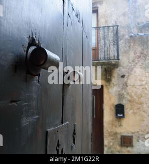 La grande e pesante porta aperta alla strada stretta. Foto Stock