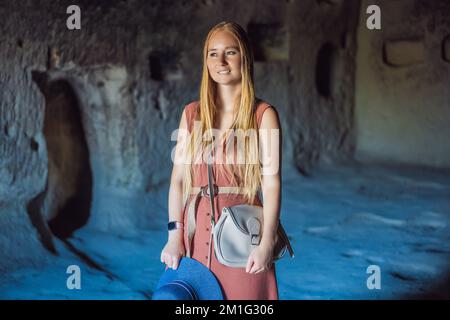 Giovane donna che esplora la valle con formazioni rocciose e grotte delle fate vicino a Goreme in Cappadocia Turchia Foto Stock