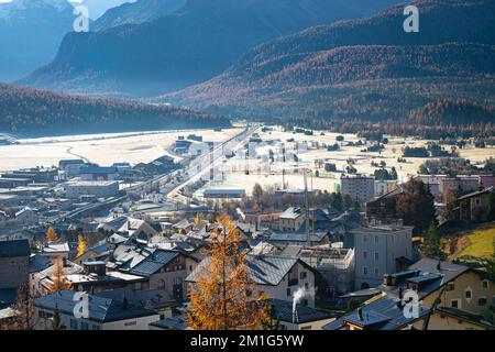 Paesaggio autunnale di montagne ricoperte di larici color oro e rime sul pavimento della valle Engadina vicino alla città di Samedan in Svizzera. Foto Stock