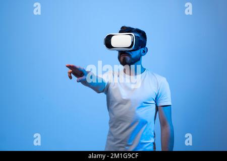 Uomo bearded in occhiali VR cercando di toccare qualcosa. Futuro, tecnologia e concetto di persone. Foto Stock
