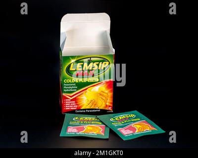 Scatola di bustine Lemsip Max che viene preso per alleviare i sintomi di raffreddore e influenza su uno sfondo nero Foto Stock