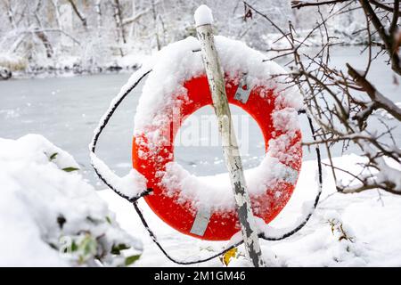 Lifebouy in neve fitta vicino allo stagno in Alexander Palace.Ready e di colore rosso brillante con accessibilità in caso di emergenza o un incidente Foto Stock