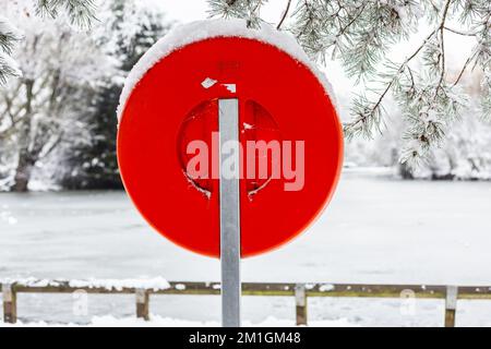 Lifebouy in neve fitta vicino allo stagno in Alexander Palace.Ready e di colore rosso brillante con accessibilità in caso di emergenza o un incidente Foto Stock