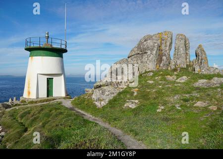 Faro con formazione rocciosa sulla costa della Galizia in Spagna, provincia di Pontevedra, Cangas, Rias Baixas Foto Stock