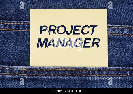 Economia e concetto di istruzione. C'è una carta che sporge da una tasca di jeans con l'iscrizione - Project Manager Foto Stock