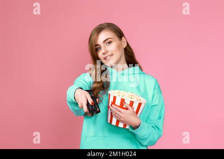 donna in 3d bicchieri con telecomando che tiene un secchio di popcorn Foto Stock