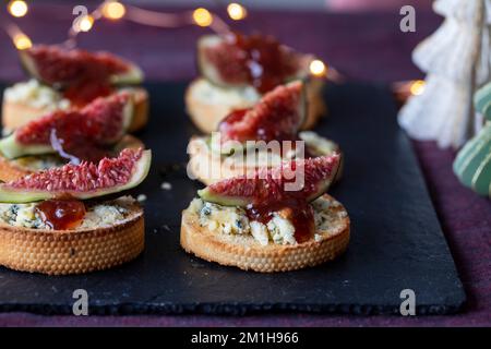 Tartine di Natale con formaggio a palettoni e fichi fritto Foto Stock