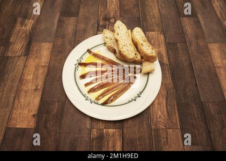 Una tipica tapa del nord della Spagna con acciughe in salamoia con olio d'oliva e pezzetti di pane tostato Foto Stock