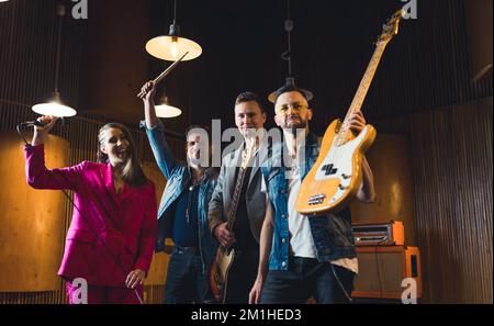 media ripresa di una band musicale che si trova felice nello studio di registrazione, concetto di musica. Foto di alta qualità Foto Stock