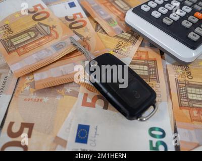 cinquanta fatture in euro su un tavolo accanto a una calcolatrice e chiavi dell'auto Foto Stock