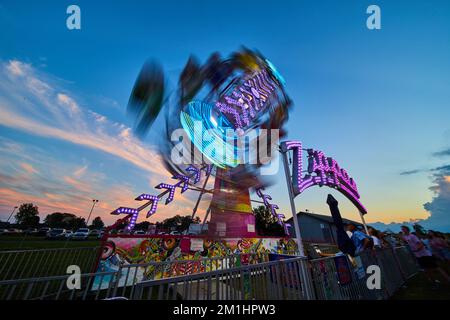 Zip carnevale contea fair ride sfocata al crepuscolo Foto Stock