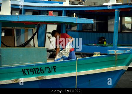 Un uomo che lavora su una barca da pesca a Kudat, Sabah, Borneo, Malesia. Foto Stock