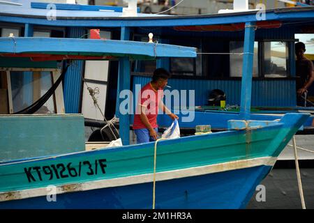 Un uomo che lavora su una barca da pesca a Kudat, Sabah, Borneo, Malesia. Foto Stock