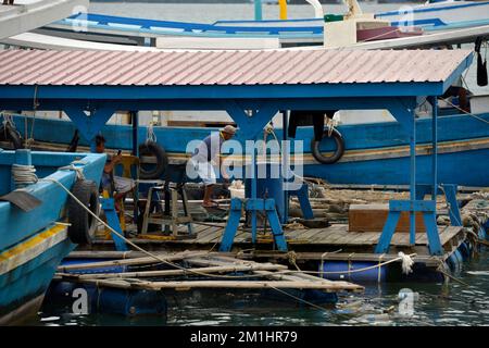 Un uomo che lavora su una barca da pesca a Kudat, Sabah, Borneo, Malesia. Foto Stock