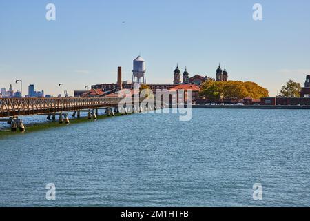 Vista di Ellis Island dalla costa del New Jersey con il ponte che conduce all'isola Foto Stock