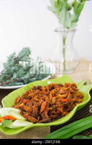 Pampis Tongkol/Cakalang, piatto di pesce tradizionale del Manado con pesce speziato, servito su un piatto verde Foto Stock