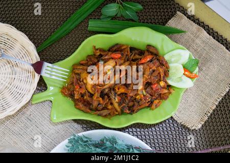 Pampis Tongkol/Cakalang, piatto di pesce tradizionale del Manado con pesce speziato, servito su un piatto verde Foto Stock