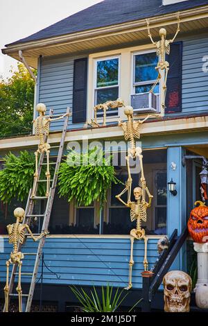 Decorazioni di Halloween all'esterno della casa con scheletri che salgono fino al tetto Foto Stock