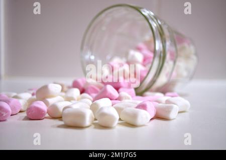 Mini, piccoli Marshmallows versati dal vaso sul banco della cucina Foto Stock