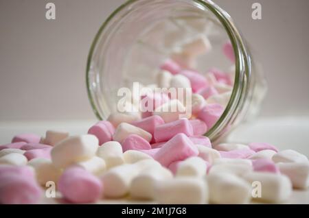 Mini, piccoli Marshmallows versati dal vaso sul banco della cucina Foto Stock