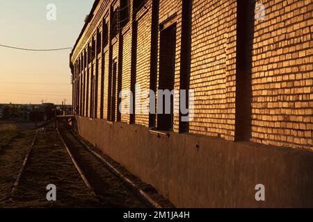 Lato del vecchio magazzino accanto a una ferrovia che si trova a Lamar, Colorado, subito dopo l'alba Foto Stock