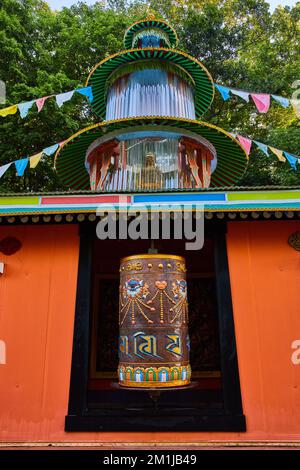 Grande ruota di preghiera ornata e bandiere di preghiera per il tempio buddista tibetano mongolo Foto Stock