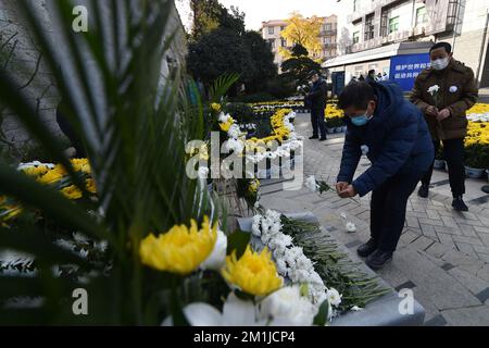 NANJING, CINA - 13 DICEMBRE 2022 - la gente presenta fiori in un monumento commemorativo per le vittime del massacro di Nanjing da parte degli invasori giapponesi a Zhe Foto Stock