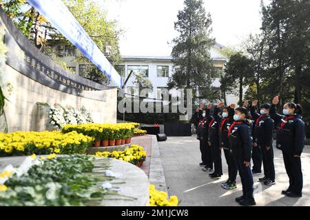 NANJING, CINA - 13 DICEMBRE 2022 - gli studenti della scuola elementare salutano i giovani pionieri al monumento delle vittime del massacro di Nanjing da parte del Giappone Foto Stock