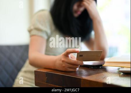 Stressato e ha rotto giovane donna asiatica che ha problemi con il suo servizio di carta di credito, ottenendo carta di credito di banca declinata, overspending. immagine ritagliata Foto Stock