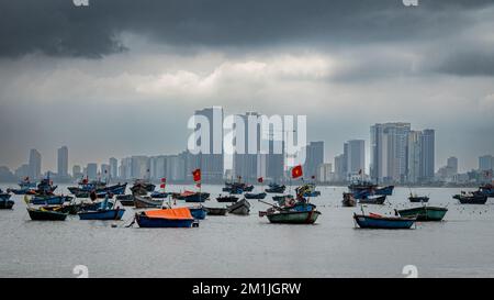 Tradizionali barche vietnamite in legno da pesca ormeggiate al largo di My Khe spiaggia di fronte alla baia dal moderno fronte mare a Danang, Vietnam. Foto Stock