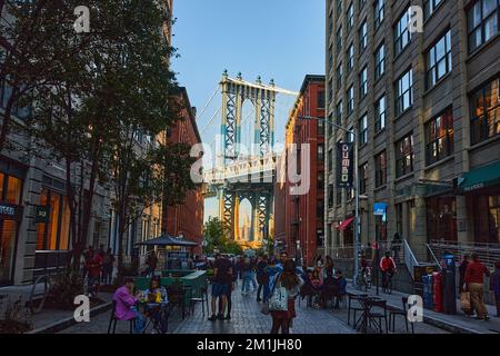 Manhattan Bridge da Brooklyn Street tra edifici al sole Foto Stock