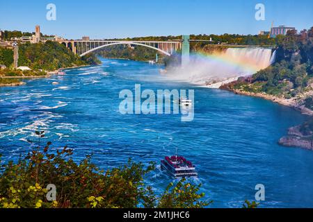 Navi turistiche sul fiume Niagara con arcobaleno e avvicinarsi Rainbow Bridge e American Falls Foto Stock