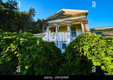 Residenza cittadina americana abbandonata in legno con grandi colonne bianche Foto Stock