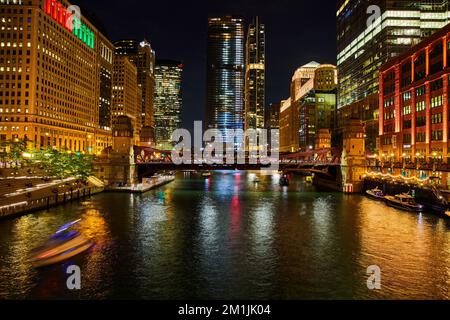 I grattacieli si illuminano nella vita notturna di Chicago lungo i canali Foto Stock