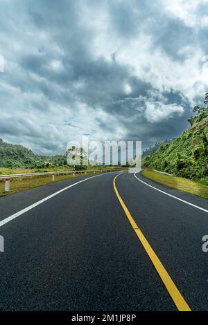 Strada curva fino alla montagna. Molti segnali di avvertenza indicano la sicurezza Foto Stock