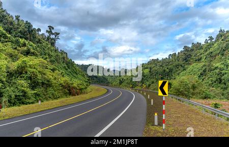 Strada curva fino alla montagna. Molti segnali di avvertenza indicano la sicurezza Foto Stock