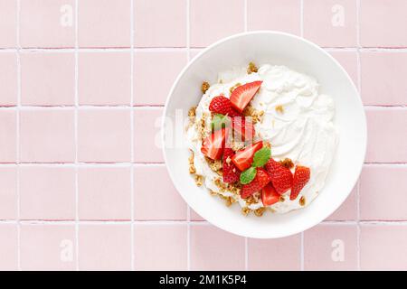 Yogurt con fragola. Yogurt greco bianco semplice con frutti di bosco freschi e muesli. Cibo sano, colazione. Vista dall'alto Foto Stock