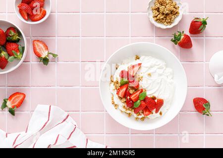 Yogurt con fragola. Yogurt greco bianco semplice con frutti di bosco freschi e muesli. Cibo sano, colazione. Vista dall'alto Foto Stock