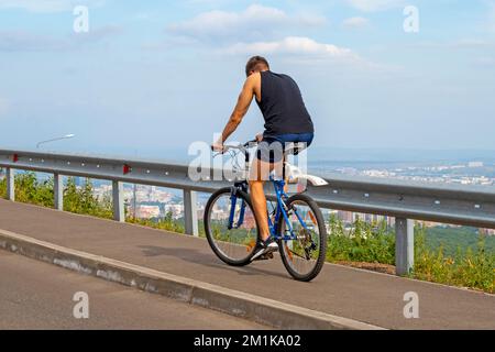 KRASNOYARSK - 12 AGOSTO: Ciclista che sale su una strada a Krasnoyarsk, il 12 agosto. 2022 in Russia Foto Stock