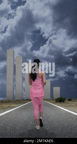 Vista posteriore della donna asiatica che corre sulla strada Foto Stock