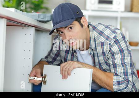 regolazione della cerniera del mobile sospeso Foto Stock