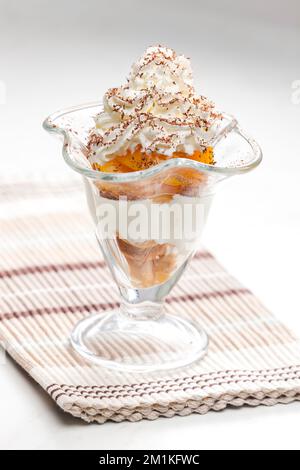 gelato con pesca stufata e panna montata Foto Stock