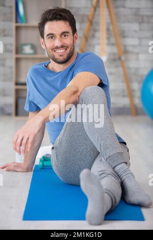 uomo sportivo e consapevole con meditare da solo a casa Foto Stock