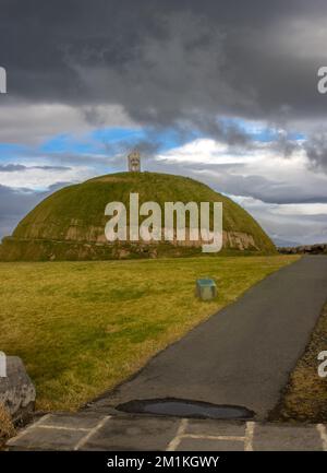 Thufa Hill come luogo di meditazione e serenità, basato sul folclore locale. Coperto da erba verde. Cielo nuvoloso piovoso. Grandi, porto di Reykjavik, Icel Foto Stock